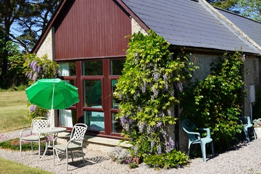 Winnow accommodation building with pitched roof and green grounds at Mossyards