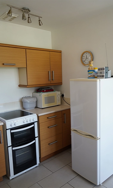 Bright kitchen corner with full-size fridge, microwave, and thoughtful little touches to make you feel at home