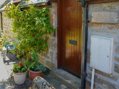 Entrance view of a Gable accommodation with modern exterior and plants
